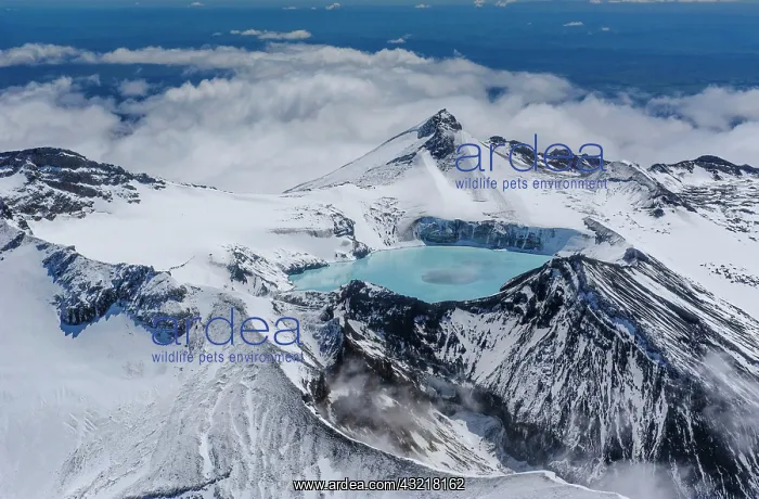 : Aerial view of a tuquoise crater lake on top of : Aerial view of a tuquoise crater lake on top of