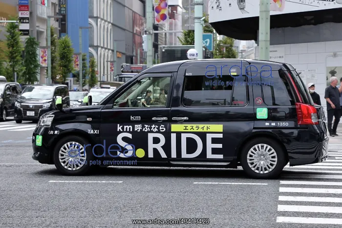 : Black Japanese taxi driving through Ginza, Tokyo, Japan : Black Japanese taxi driving through Ginza, Tokyo, Japan