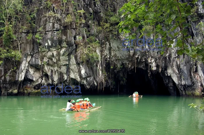 : Boats with tourists enter the cave, that features : Boats with tourists enter the cave, that features