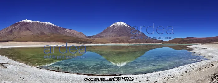 : Broad mountain backdrop with two snow-covered peaks reflected in a calm lake : Broad mountain backdrop with two snow-covered peaks reflected in a calm lake