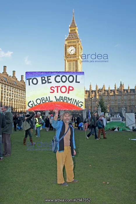 : Campaigner with banner Be cool stop global warming : Campaigner with banner Be cool stop global warming