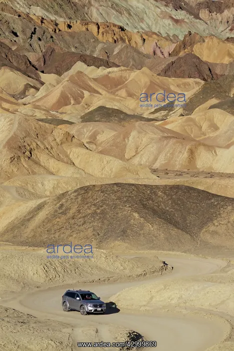 : Car on the loop road through the otherwordly badlands : Car on the loop road through the otherwordly badlands