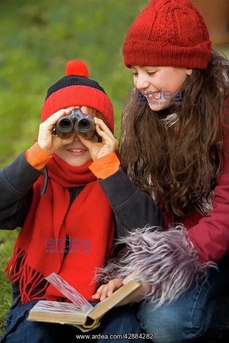 : Children - boy and girl birdwatching with binoculars : Children - boy and girl birdwatching with binoculars