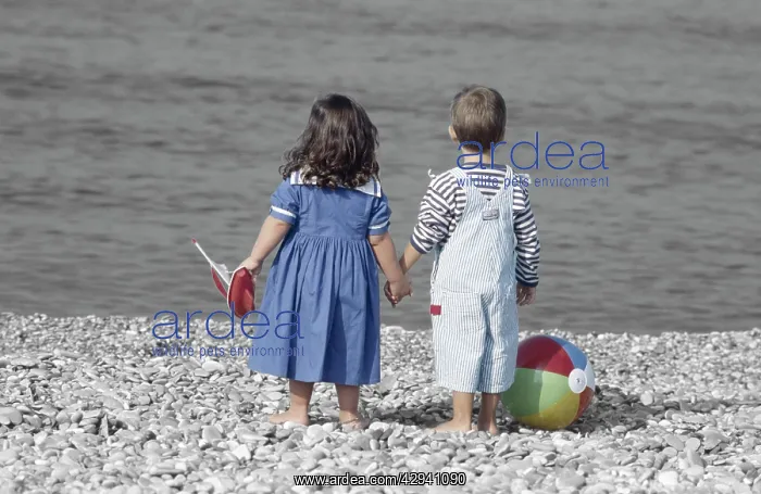: Children - boy & girl holding hands on beach, with : Children - boy & girl holding hands on beach, with
