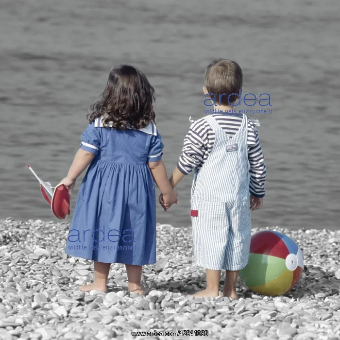 : Children - boy & girl holding hands on beach, with : Children - boy & girl holding hands on beach, with