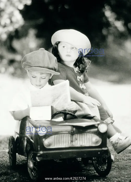  : Children - boy and girl in toy car reading map