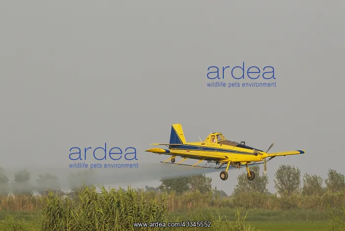 : Crop duster plane flying low while spraying an anti : Crop duster plane flying low while spraying an anti