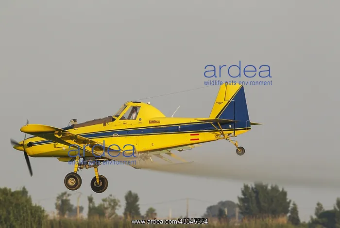 : Crop duster plane flying low while spraying an anti : Crop duster plane flying low while spraying an anti