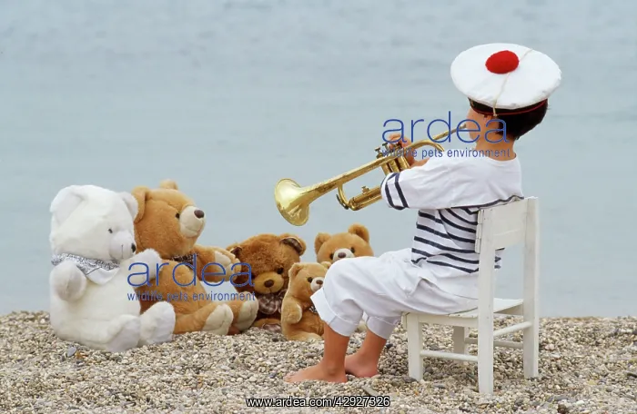 : Cute - child on beach with teddy bears & trumpet : Cute - child on beach with teddy bears & trumpet