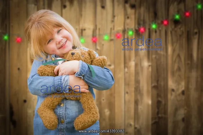 : Cute little girl holding her teddy bear in front : Cute little girl holding her teddy bear in front
