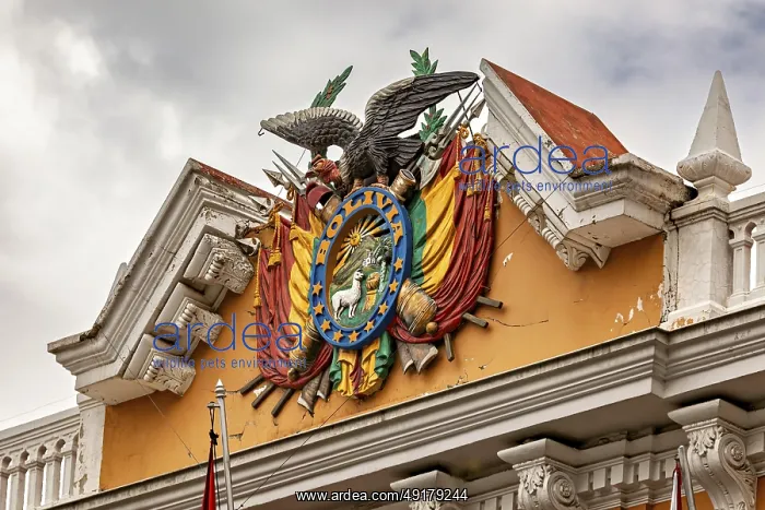: Detailed coat of arms with eagle on a historic building under a cloudy sky : Detailed coat of arms with eagle on a historic building under a cloudy sky