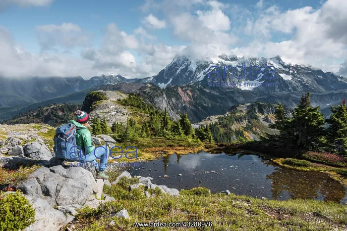 : Female hiker resting on a rock at a small mountain : Female hiker resting on a rock at a small mountain