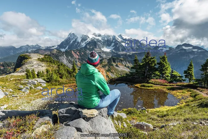 : Female hiker resting on a rock at a small mountain : Female hiker resting on a rock at a small mountain