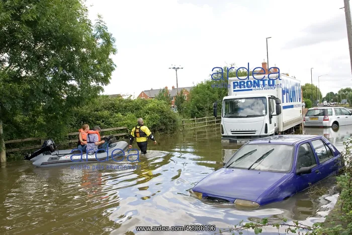 : Flooding - rescue workers taking people in inflatable : Flooding - rescue workers taking people in inflatable