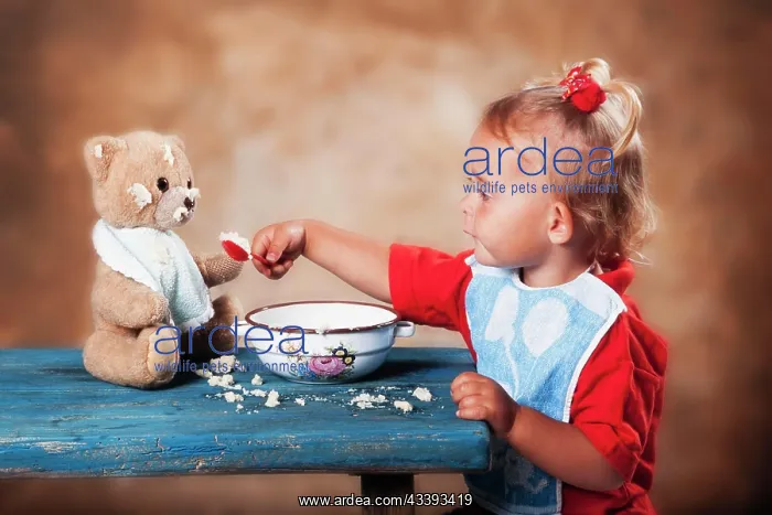 : Four-year old girl feeding teddy bear, Austria : Four-year old girl feeding teddy bear, Austria