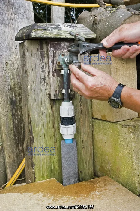 : Garden Tap - person repairing brass leaking tap : Garden Tap - person repairing brass leaking tap