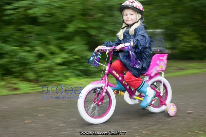 : Girl aged four wearing cycle helmet riding brightly : Girl aged four wearing cycle helmet riding brightly