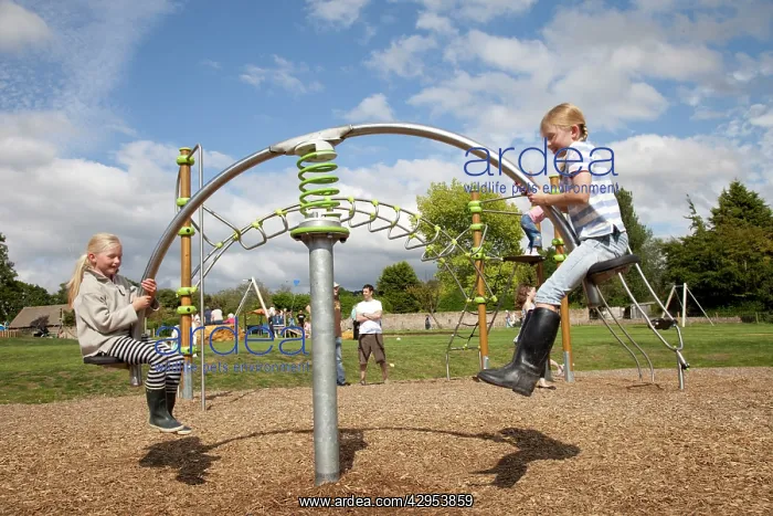 : Two girls enjoying hi-tech seesaw at new playground : Two girls enjoying hi-tech seesaw at new playground