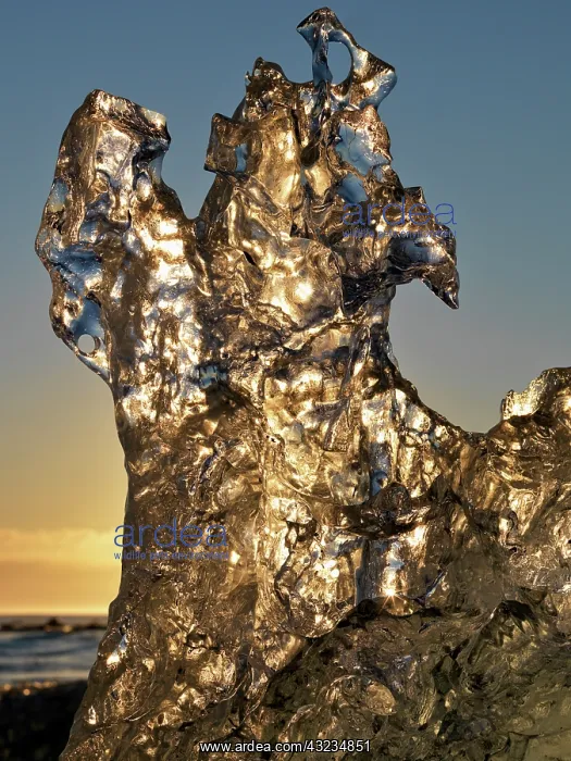 : Golden sunrise seen through iceberg formation : Golden sunrise seen through iceberg formation
