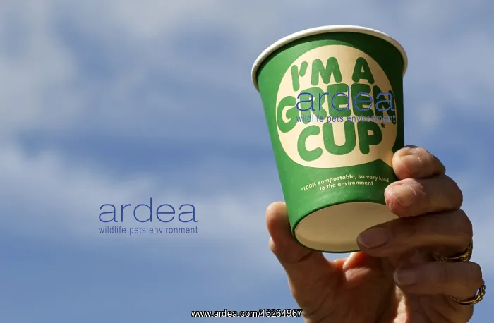 : Hand holding 100% compostable Green recyclable coffee : Hand holding 100% compostable Green recyclable coffee