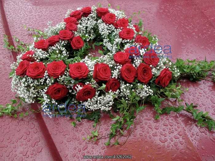 : Heart-shaped floral bouquet on a car in the rain : Heart-shaped floral bouquet on a car in the rain