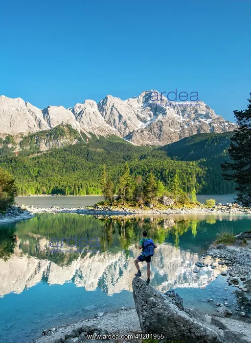 : Hiker standing on rocks, view into the distance : Hiker standing on rocks, view into the distance