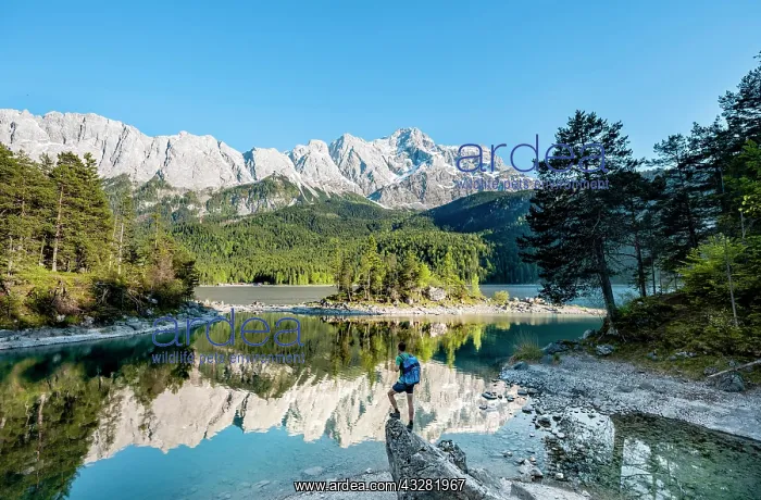 : Hiker standing on rocks, view into the distance : Hiker standing on rocks, view into the distance