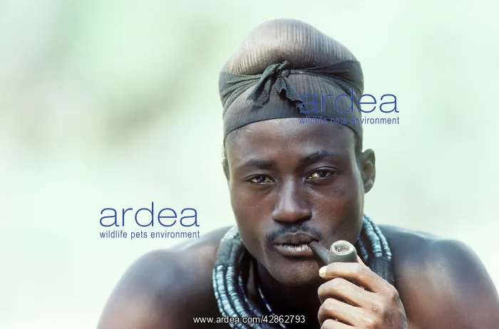 : Himba man smoking a pipe - the head scarf indicates : Himba man smoking a pipe - the head scarf indicates