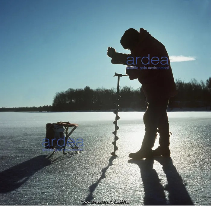  : Ice fishing with drill in winter