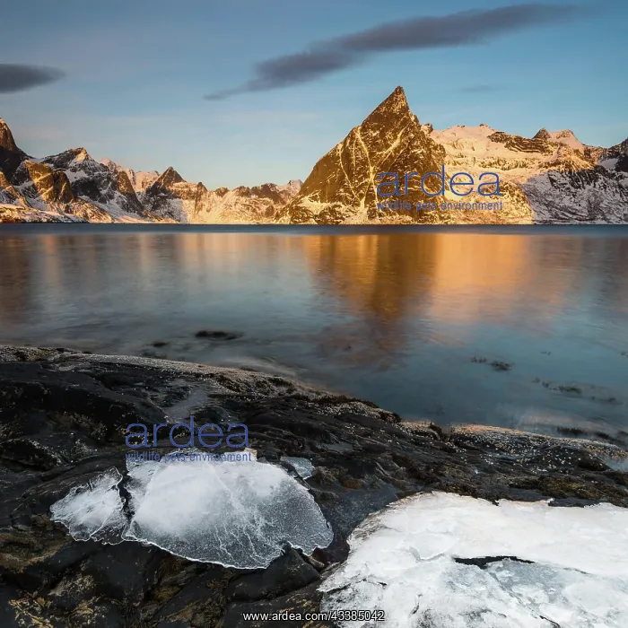  : Ice sheets on dark rock with lake and snow-clad s