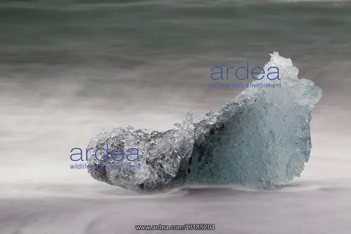 : Iceblock on the beach with splashing seawater : Iceblock on the beach with splashing seawater