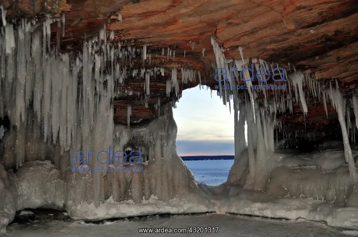 : Icicles and ice formations in a cave and view through : Icicles and ice formations in a cave and view through