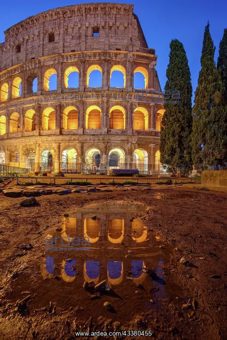 : The illuminated Colosseum in Rome at dusk with a : The illuminated Colosseum in Rome at dusk with a