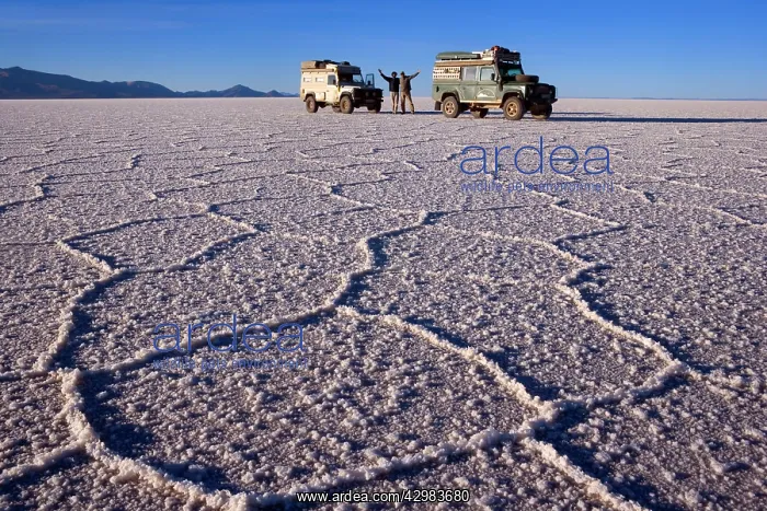 : Landrovers on Salar de Uyuni - two tourists with : Landrovers on Salar de Uyuni - two tourists with