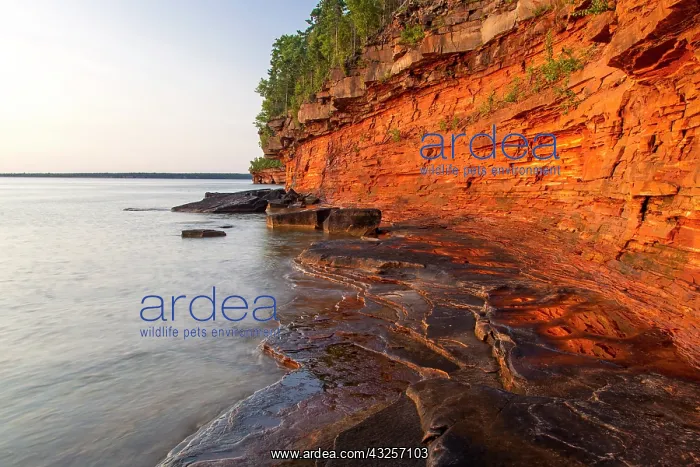 : Layered sandstone cliffs and sea caves at : Layered sandstone cliffs and sea caves at