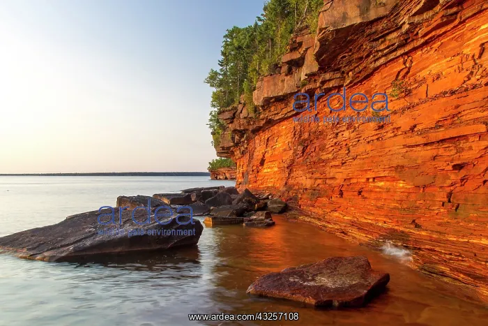 : Layered sandstone cliffs and sea caves at : Layered sandstone cliffs and sea caves at