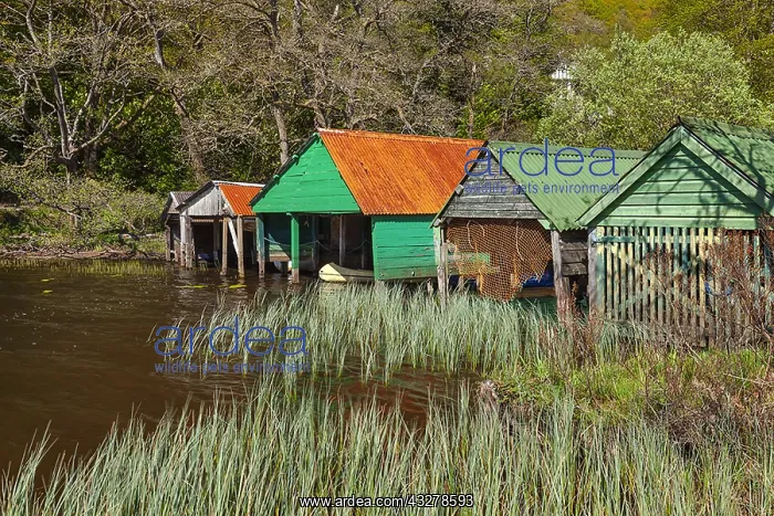 : Loch Ard - colourful wooden boat houses along the : Loch Ard - colourful wooden boat houses along the