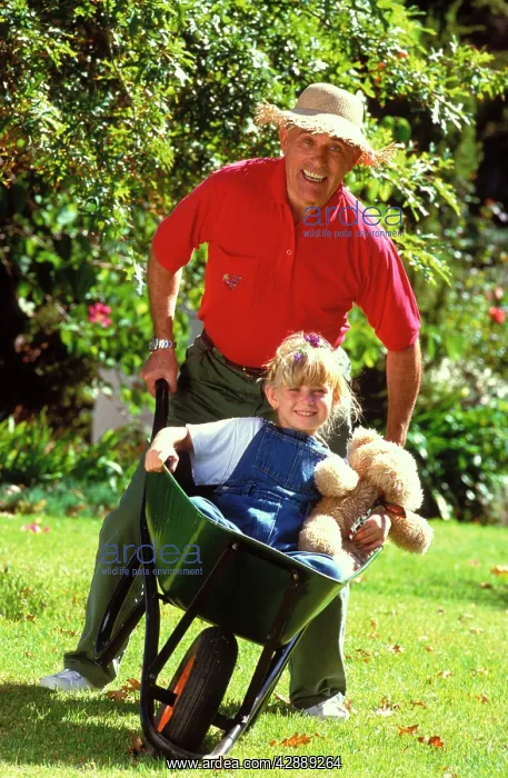 : Man with girl in wheelbarrow : Man with girl in wheelbarrow