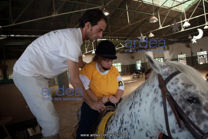 : Man helping a paraplegic woman to ride : Man helping a paraplegic woman to ride