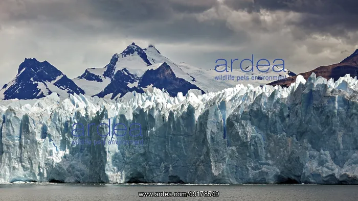: Mighty glacier landscape against a dark sky and snow-capped mountains in the background : Mighty glacier landscape against a dark sky and snow-capped mountains in the background