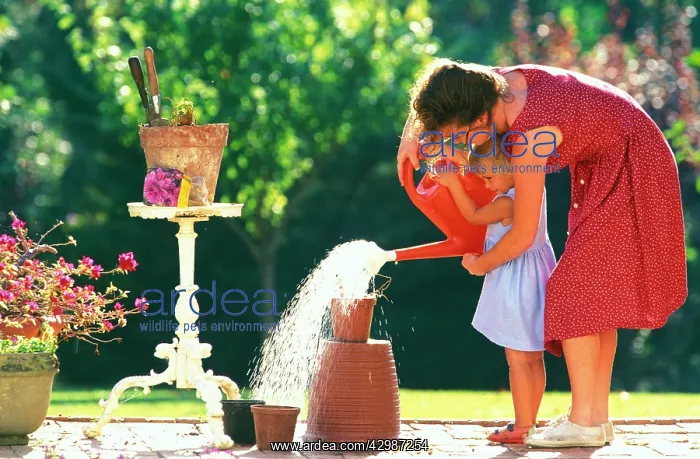 : Mother and Daughter - gardening, watering plant : Mother and Daughter - gardening, watering plant