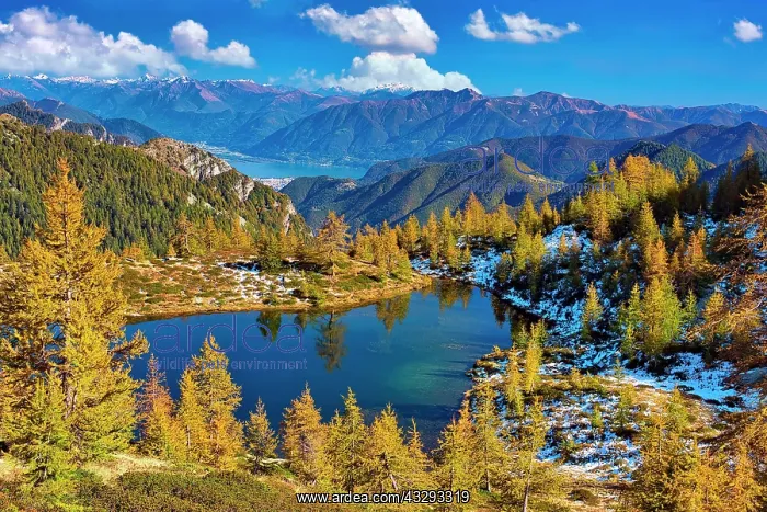 : Mountain lake surrounded by autumnal larches, Alpe : Mountain lake surrounded by autumnal larches, Alpe