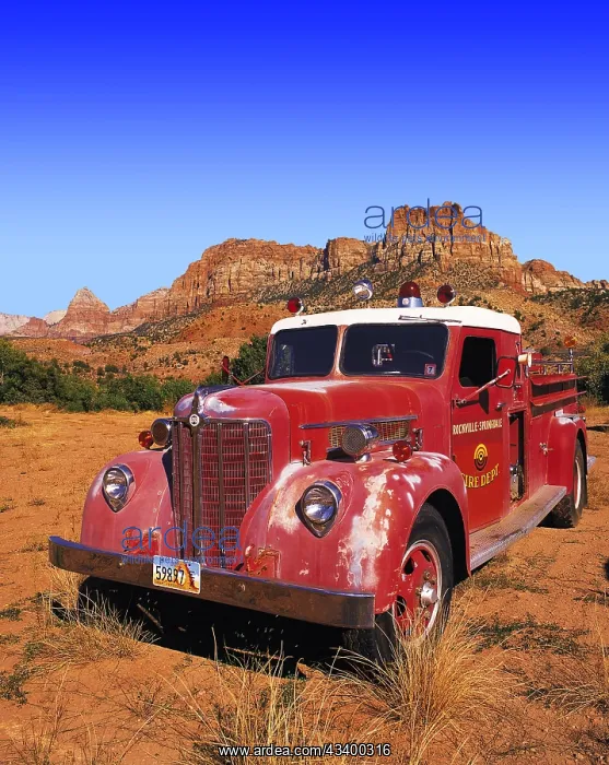 : Old-style red fire engine parked on scrubland at : Old-style red fire engine parked on scrubland at