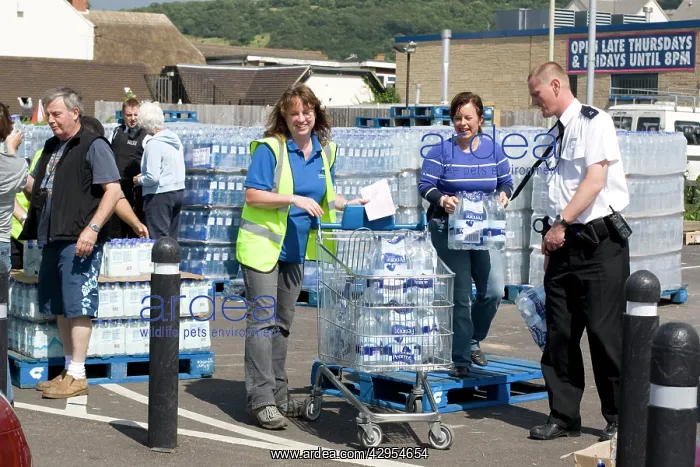 : People collecting free bottled water from Tesco car park : People collecting free bottled water from Tesco car park