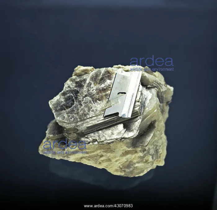: Mica. A razor blade cuts through the finely layered structure of the mineral mica : Mica. A razor blade cuts through the finely layered structure of the mineral mica