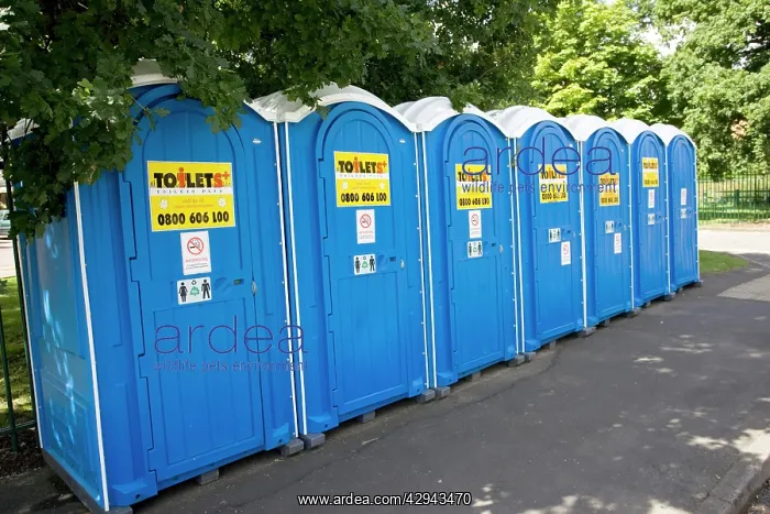: Row of blue Portaloos installed on pavement outside : Row of blue Portaloos installed on pavement outside