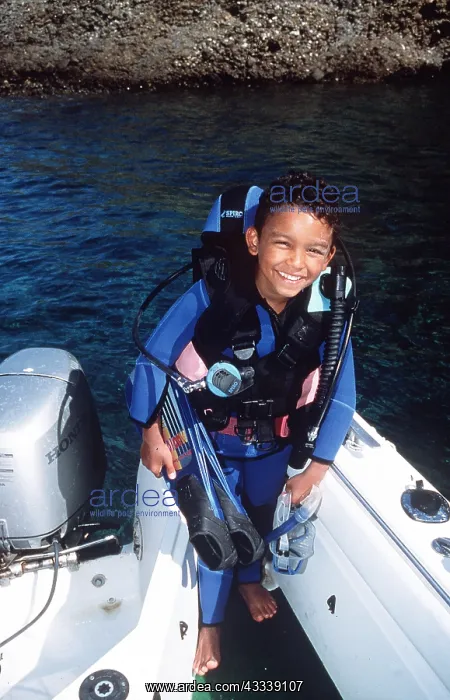 : Scuba diver boy in back of boat : Scuba diver boy in back of boat