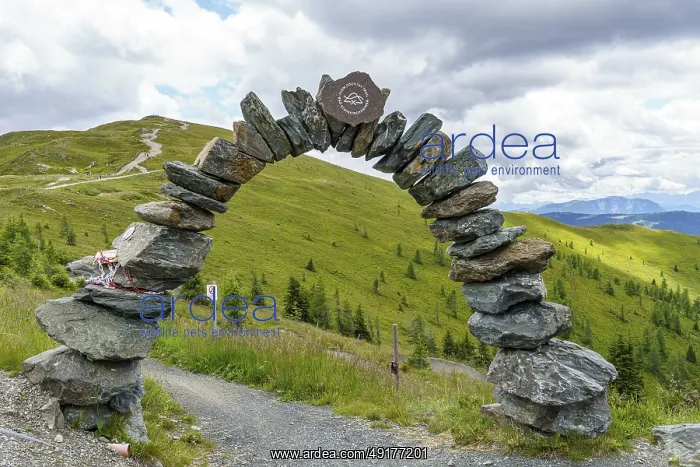 : Stone arch on a hiking trail with a view of green hills and cloudy sky : Stone arch on a hiking trail with a view of green hills and cloudy sky