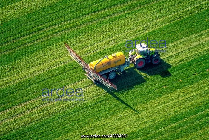 : Tractor with pesticide sprayer on meadow, fertilizing : Tractor with pesticide sprayer on meadow, fertilizing