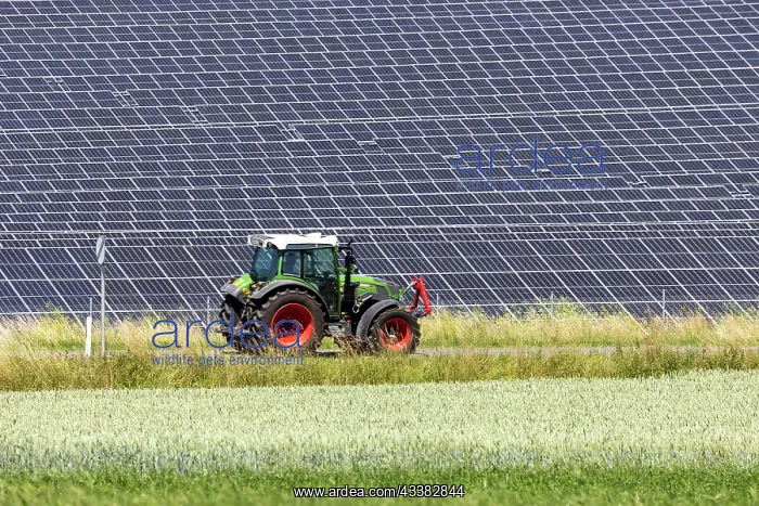  : Tractor in front of solar field, solar park in the